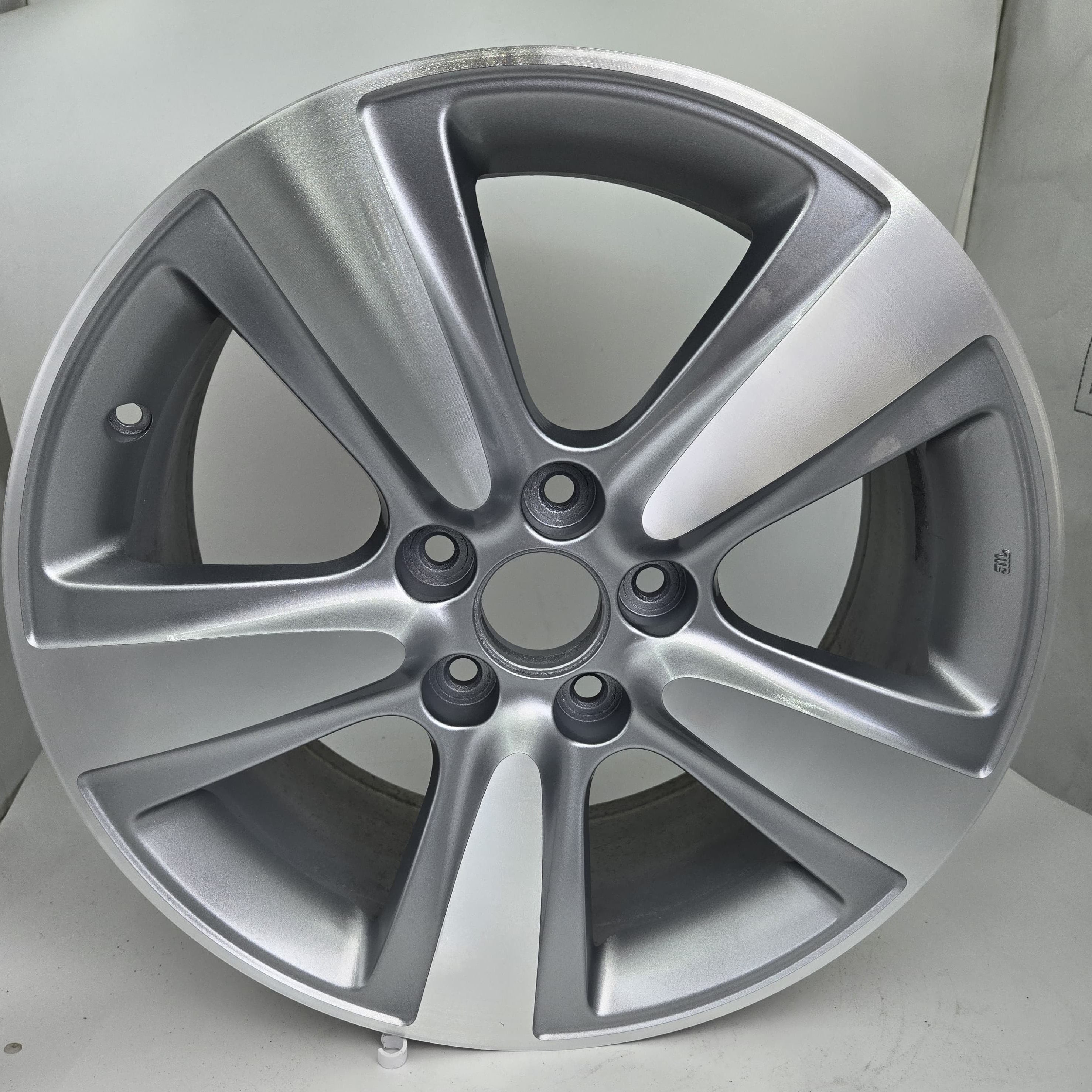 Silver alloy wheel on a light gray background