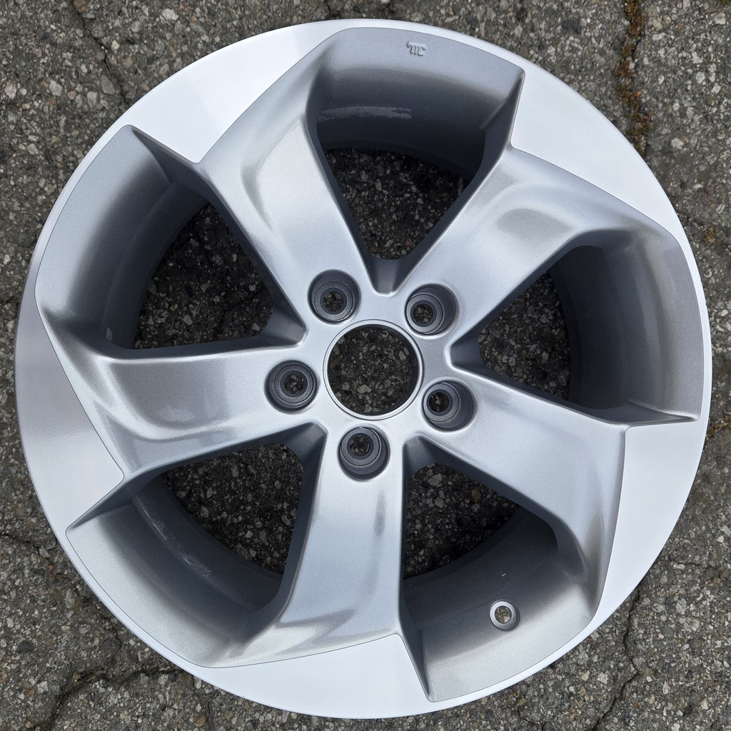 Car wheel rim on a cracked pavement surface
