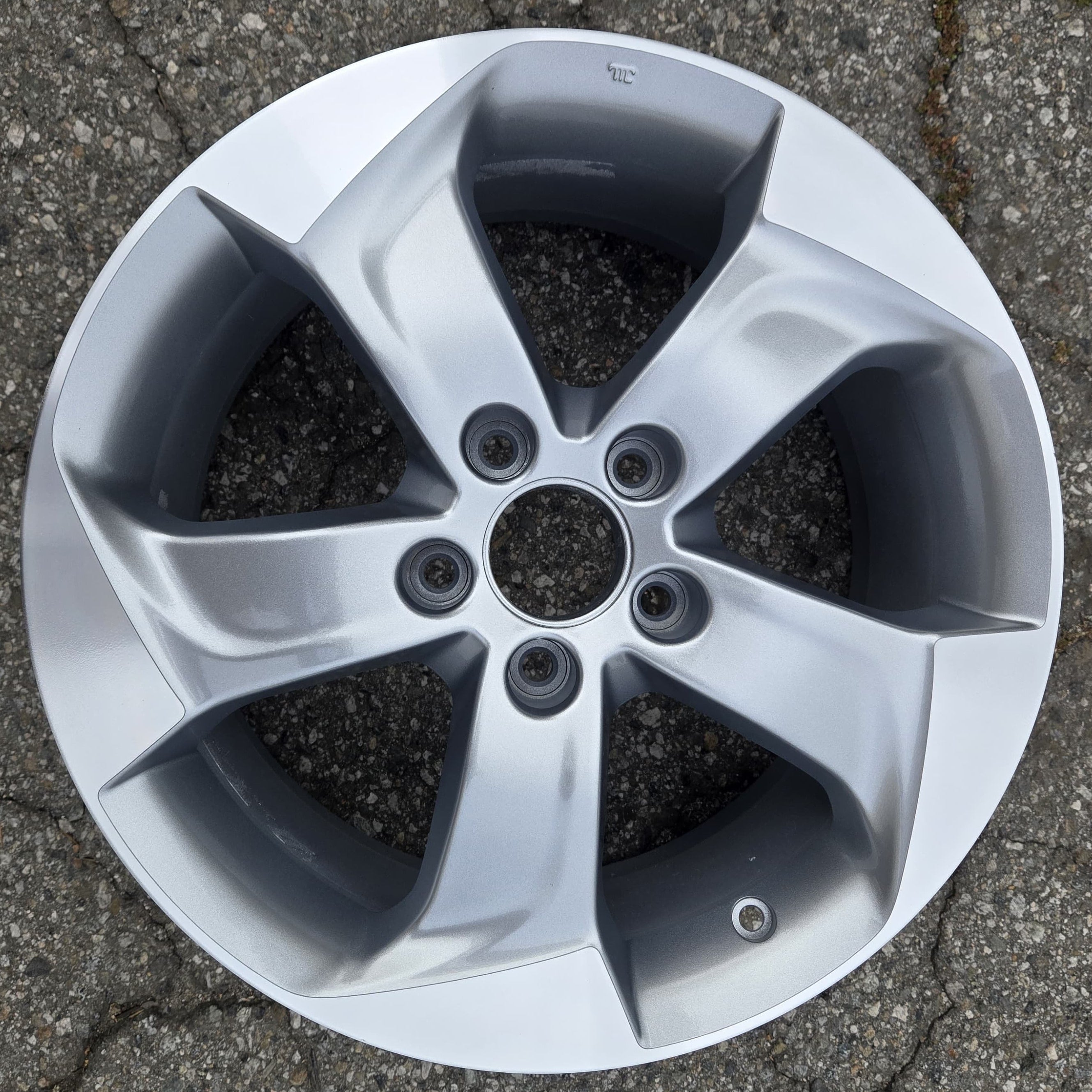 Car wheel rim on a cracked pavement surface
