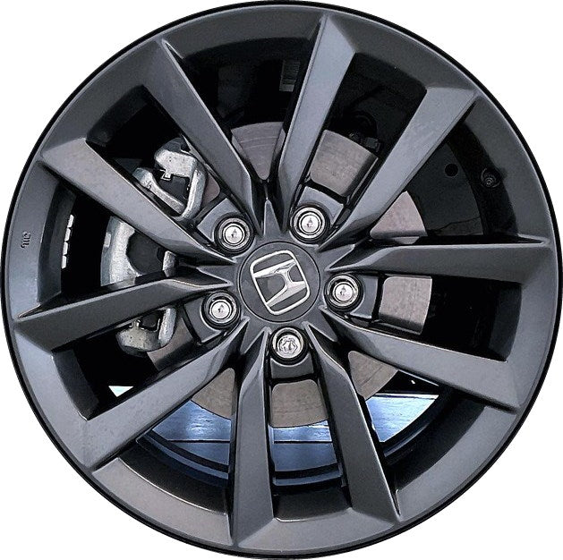 Close-up of a car wheel rim with a Honda logo on a white background