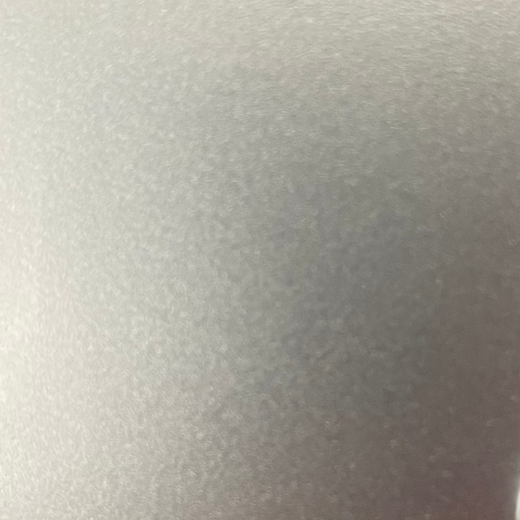 A close-up of a light gray textured surface, likely a material or color swatch.