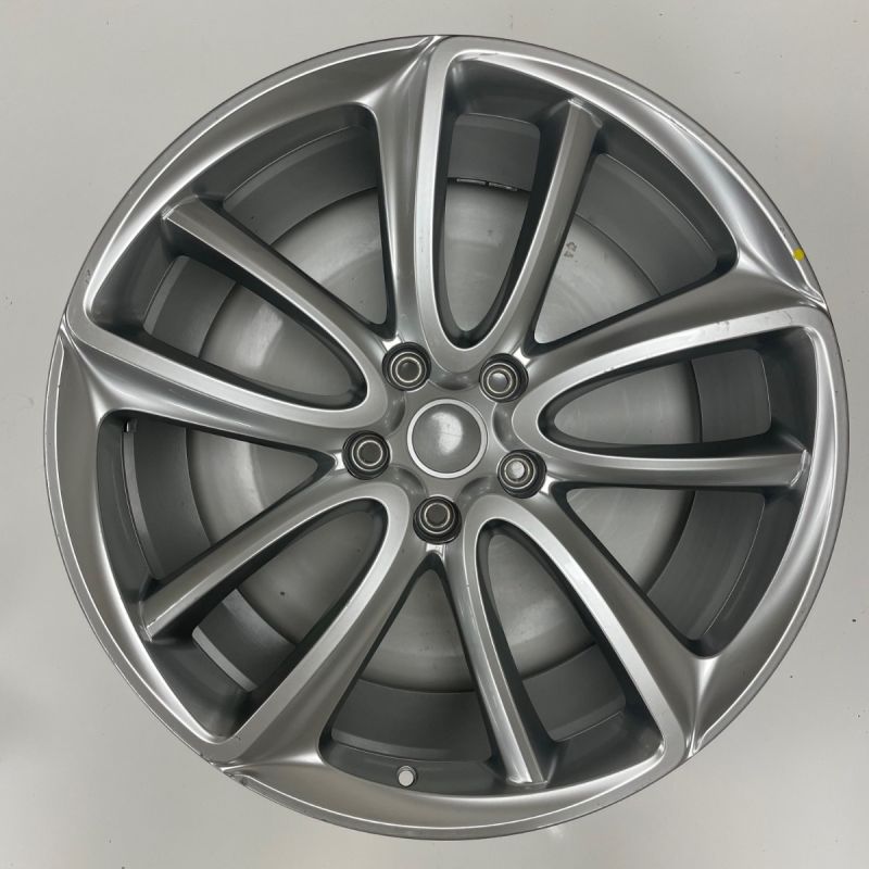 Silver car wheel rim on a gray background