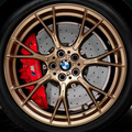 Close-up of a BMW wheel with gold finish and red brake caliper.