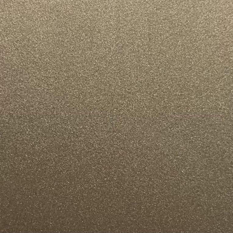 A close-up of a textured metallic gold surface with a fine, granular finish.
