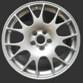 A silver multi-spoke alloy car wheel rim photographed from above on a plain gray surface.