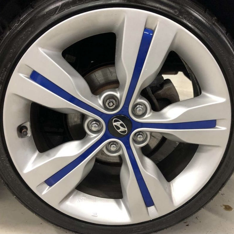Car wheel with silver rim and blue accents, featuring a Hyundai logo.