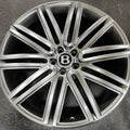 Silver car wheel rim with Bentley logo on a dark background