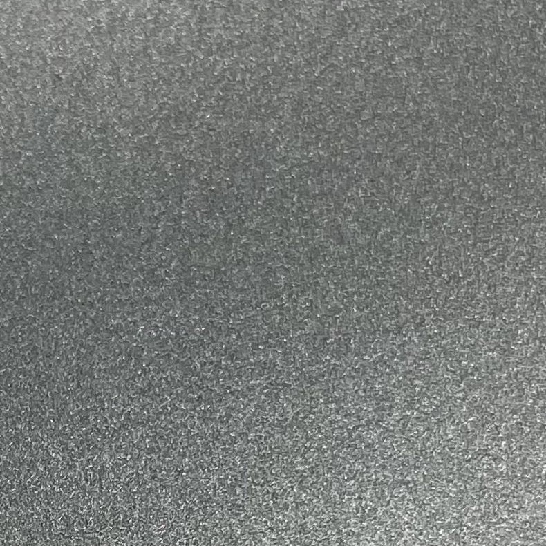 A close-up texture of a dark gray, metallic, or glittery fabric/material surface filling the entire frame.