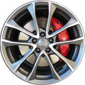 A close-up of a silver multi-spoke alloy wheel with a red brake caliper visible behind it, isolated on a white background.