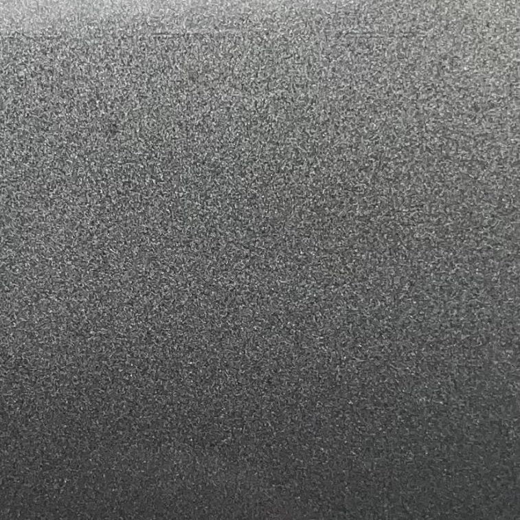 A close-up texture shot of a dark gray, speckled material with a fine granular surface.