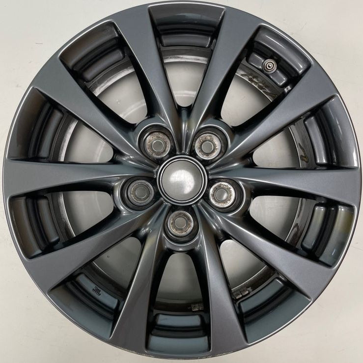 A dark gray multi-spoke alloy wheel rim photographed from directly above on a light gray background.