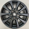 A dark gray multi-spoke alloy wheel rim photographed from directly above on a light gray background.
