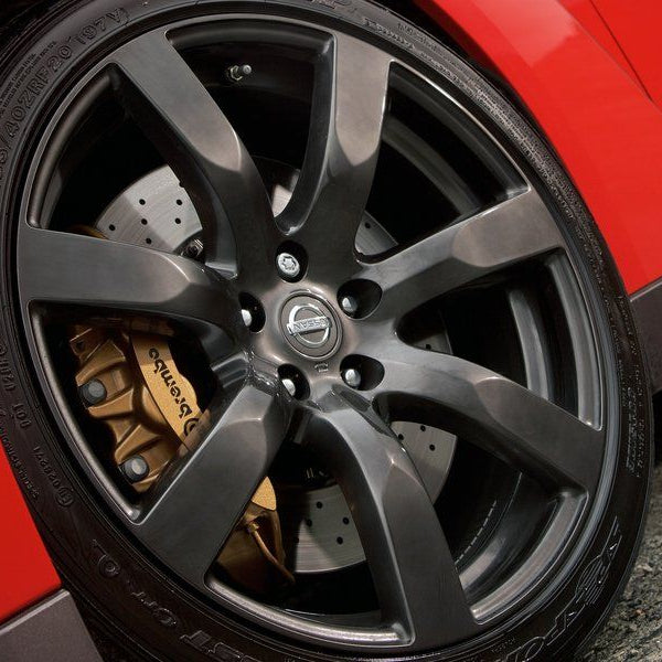 Close-up of a car wheel with a red vehicle background