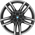A multi-spoke BMW alloy wheel rim with a dark gray and silver finish, featuring the BMW logo in the center, shown on a plain white background.